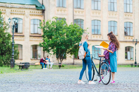 拥有自行车和笔记本的学生在大学图片