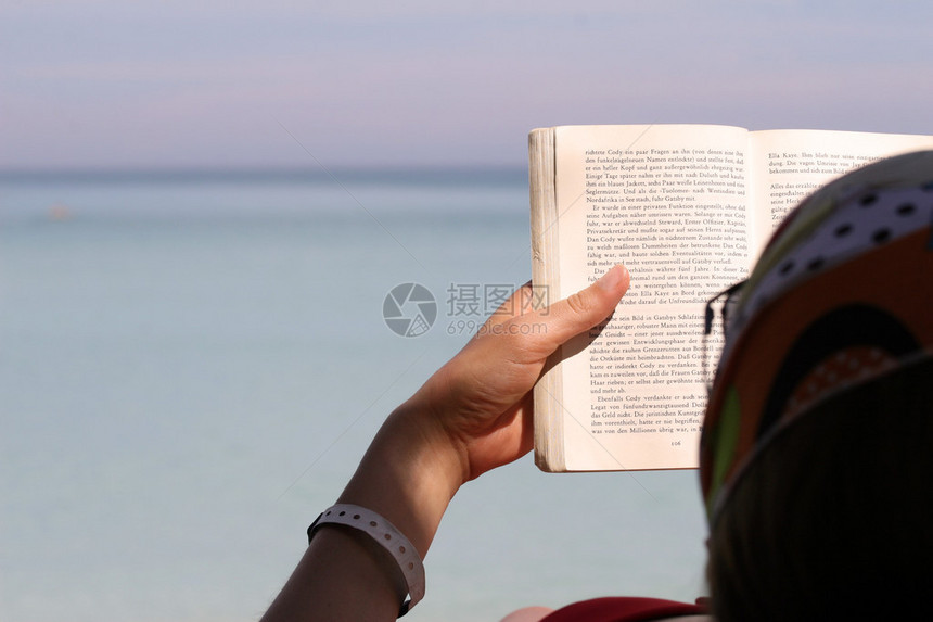 在沙滩上看书的女人图片
