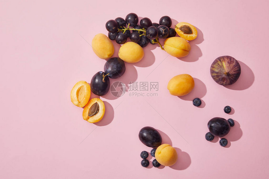 紫色背景中新鲜成熟的甜杏葡萄李子蓝莓和无花果的顶视图图片