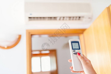 使用遥控装置对家庭空调机的温度作近图片