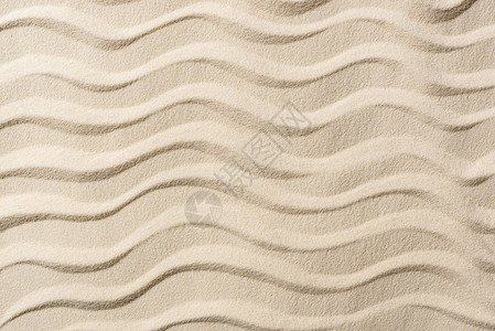 带沙子和平滑波浪的纹理背景的顶视图背景图片