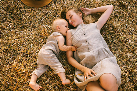 身穿单衣躺在干草上的母亲图片