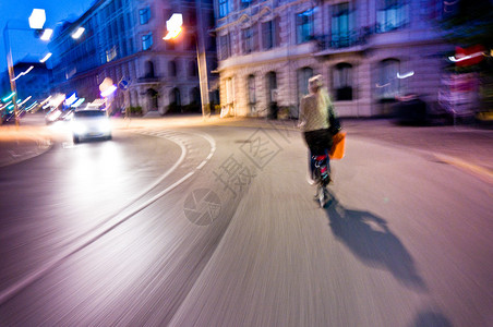妇女晚上骑自行车真正的模糊和充图片