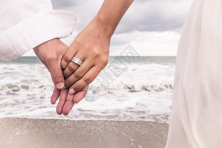 两只手在沙滩上戴戒指图片