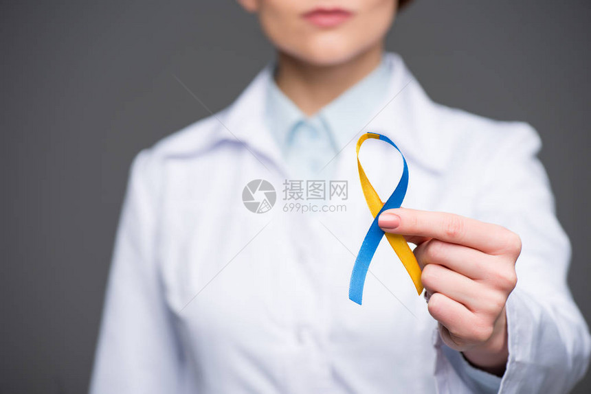 在唐氏综合症日使用蓝色和黄色丝带的女医生图片