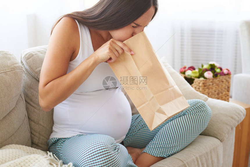 孕妇感觉不适和孕吐的侧面图使用纸气囊图片