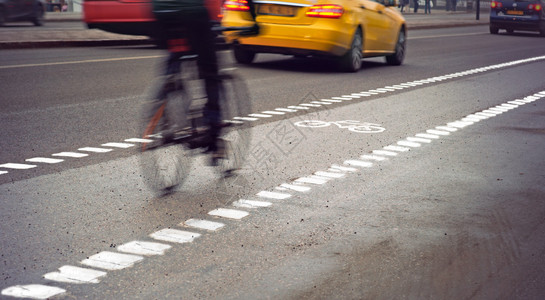 阴雨天在繁忙街道上运动模糊的自行车手图片