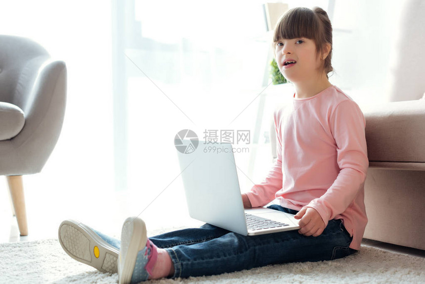 儿童在坐地上时使用笔记本电图片