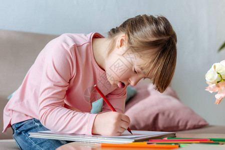 患有唐氏综合症的孩子用彩色铅笔热情地画图片