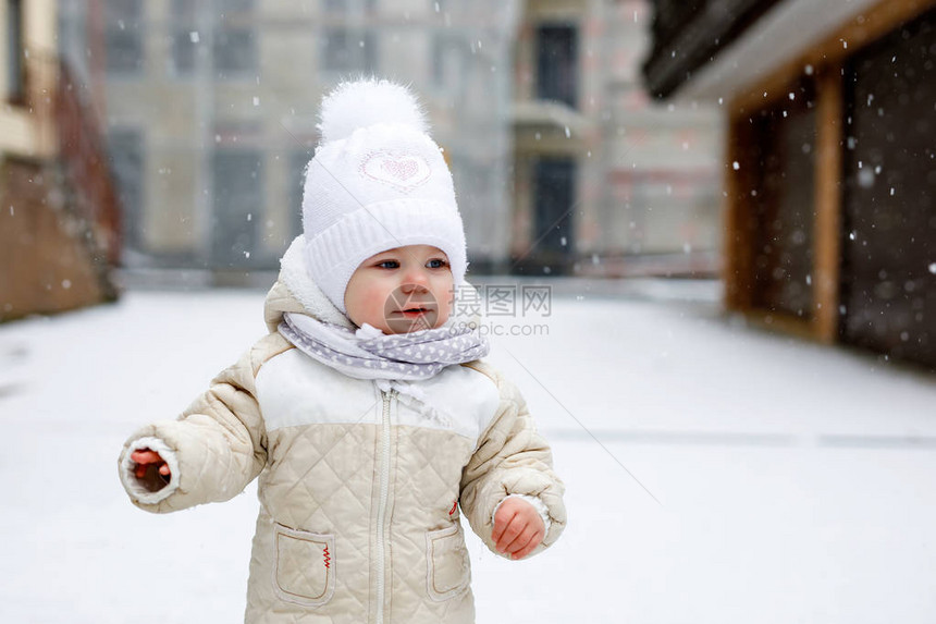 可爱的小女婴在冬天户外迈出第一步可爱的蹒跚学步的孩子学习走路孩子在寒冷的雪天玩得开心穿着温暖的婴儿粉红色衣服和图片