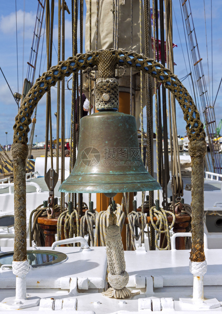 船甲板特写镜头与风帆绳索和由铜制成的老钟图片