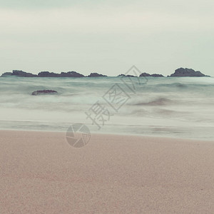 柔和色调的海浪和岩石景观图片