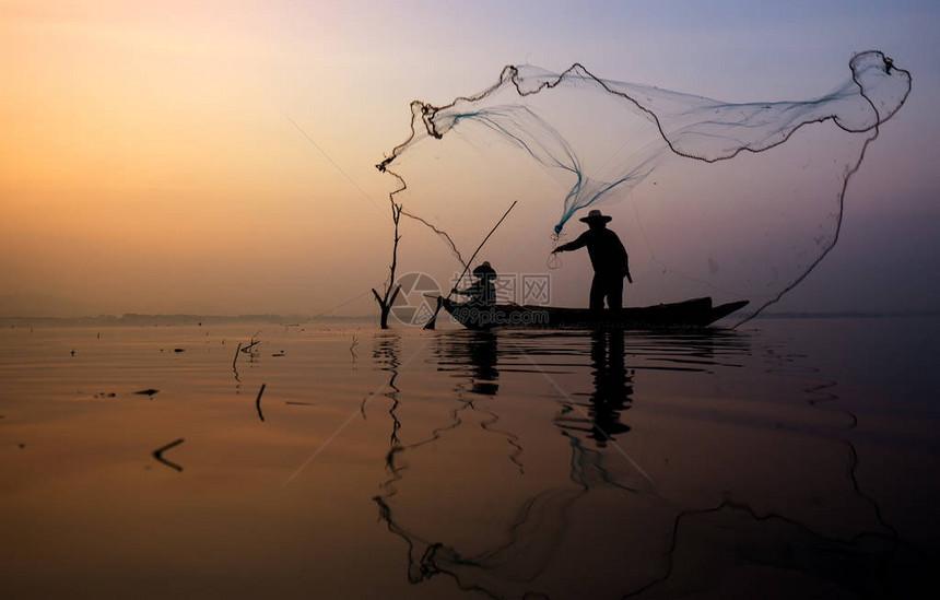 在泰国湖边钓鱼的渔夫船上的渔图片