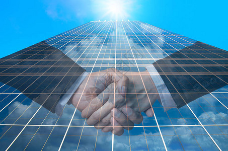 商务人士在现代玻璃建筑背景下的握手图片