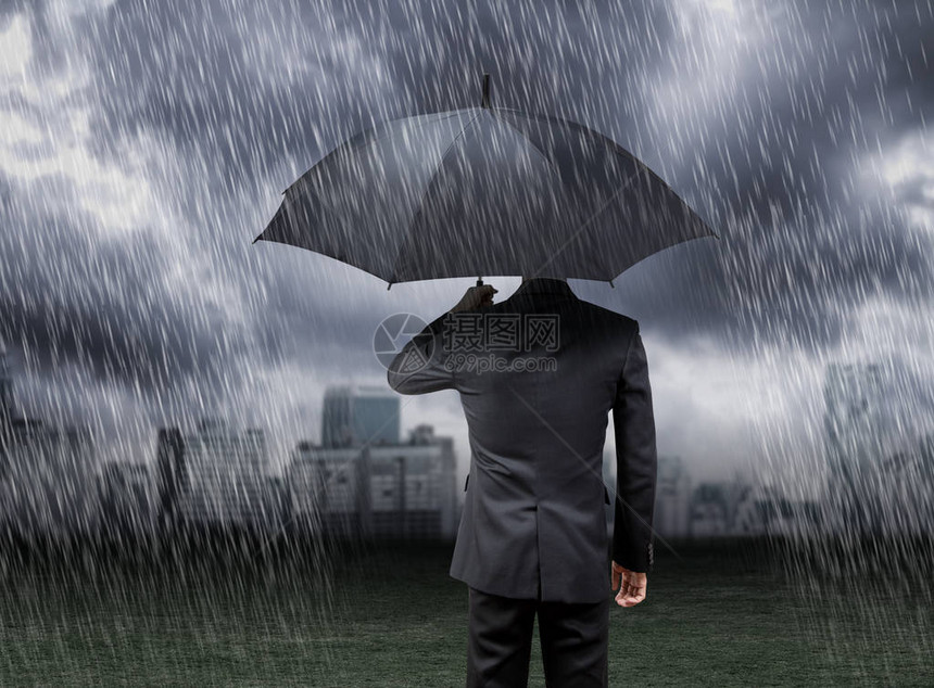 商人在暴雨下撑伞城市背景图片