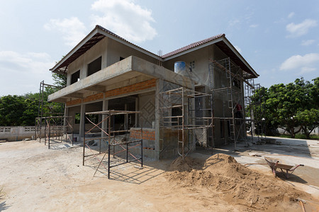 建筑工人用脚手架钢建造住宅建筑房屋图片