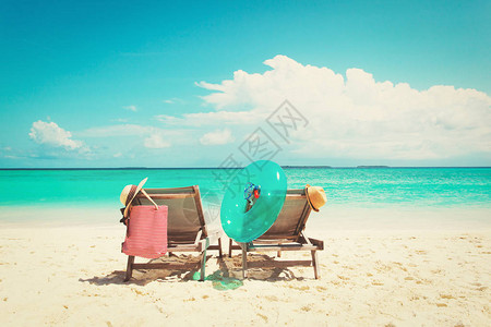 在热带沙滩度假的两把沙滩椅图片