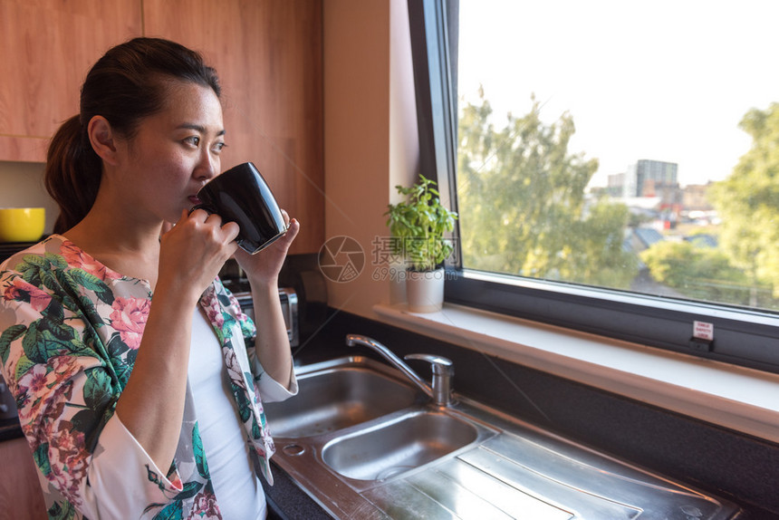 聪明的亚洲女商人早上在厨房喝咖啡在她上班前就图片