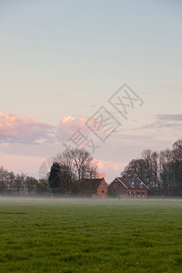 日落时雾中与房屋同房的草地云天春图片