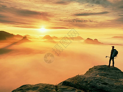 手持带杆子的木轮阳光春夏和导游留在山尖悬崖上在迷雾谷上空的岩石观察点图片