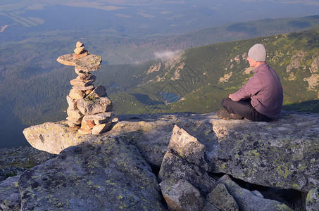 男游客坐在山顶上图片