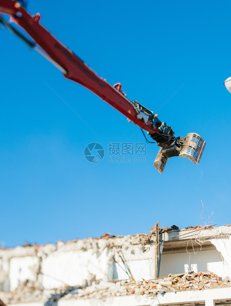 连接到挖掘机臂的铰接式机械钳口造成的建筑物或拆除或破坏图片