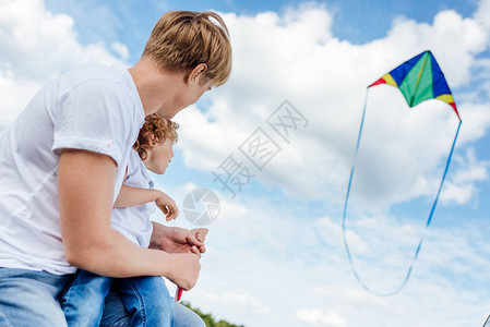 快乐的父亲和儿子在公园玩风筝图片