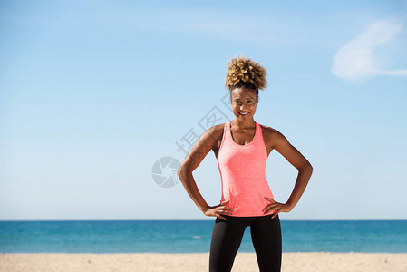 健康的黑人年轻女子的肖像在海滩上手图片