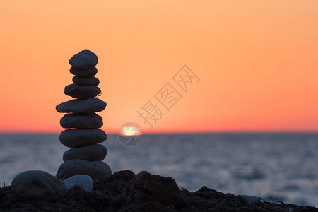 海边日落的圆形石头金字塔图片