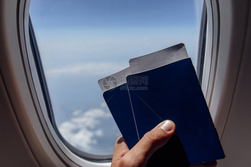 关于持有护照和机票的男子在飞机入口处图片