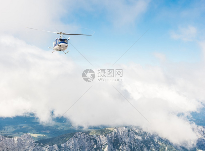 直升机飞越山脊云图片