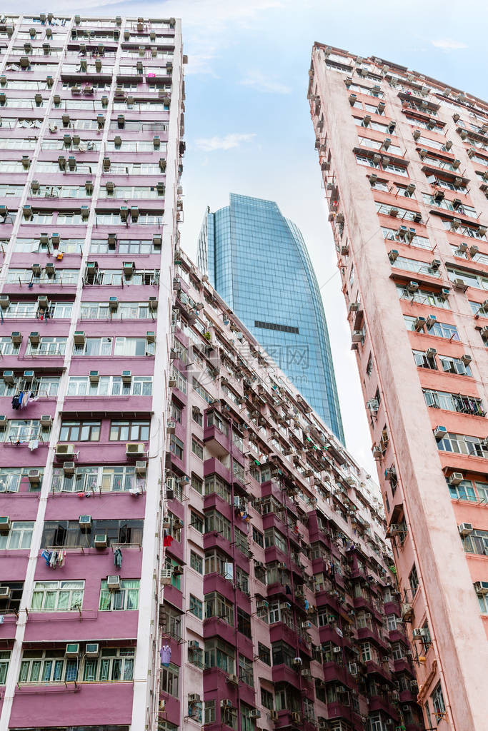 一座现代摩天大楼耸立在香港鲗鱼涌旧住宅区拥挤的住宅区之上图片