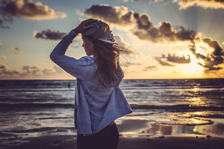 身穿棒球帽的女在海面和日图片
