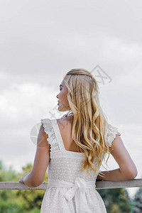 美丽的年轻金发美女的背影穿着白裙子图片
