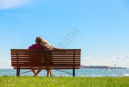 坐在蓝天空背景的公园长椅图片