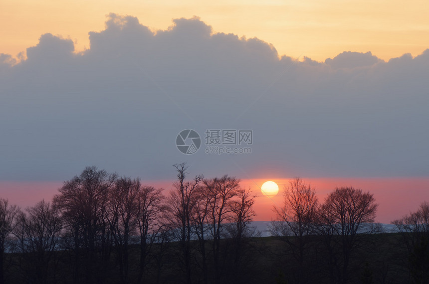 黄昏的风景树木后面有日落的太阳山上也图片