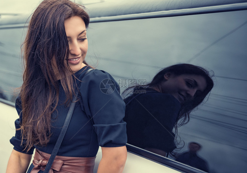 美丽的年轻女子在汽车玻璃的反射中图片
