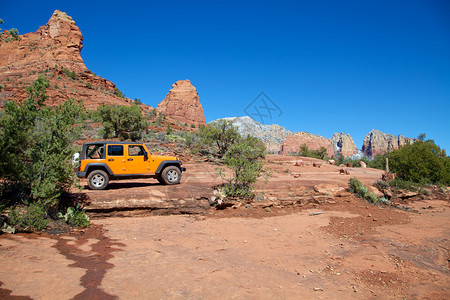 一辆吉普车探索美丽的红岩的西图片