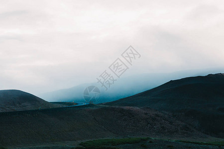 阴天壮丽的冰岛景观山丘和柏油路图片
