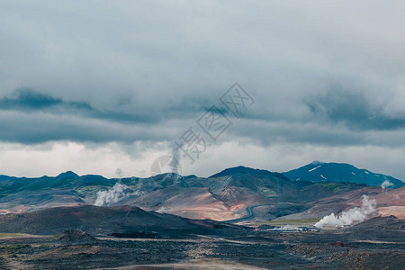 云端有山峰和温泉蒸汽的冰雪地貌图片