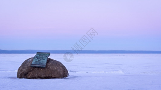 冬季在湖岸的巨石上的纪念铜图片