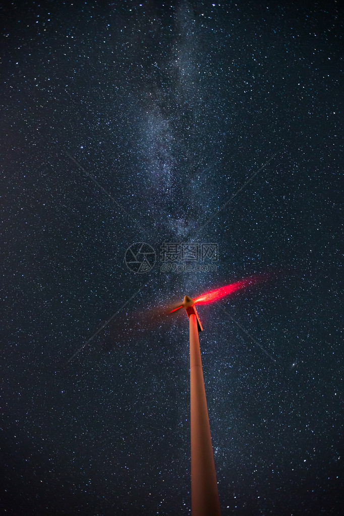 在满天星斗的夜空与银河的风力涡轮机图片