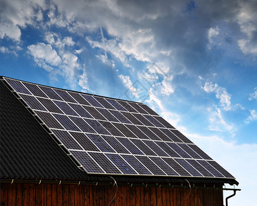 日落时房子屋顶上的太阳能电池板图片