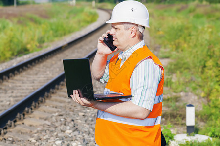 铁路工程师在铁路附近配备智能手机图片