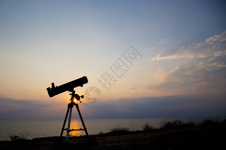 在日落背景的望远镜剪影图片