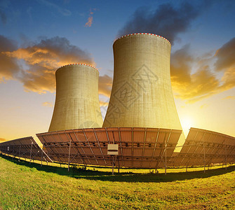 日落时的太阳能电池板和核电站图片