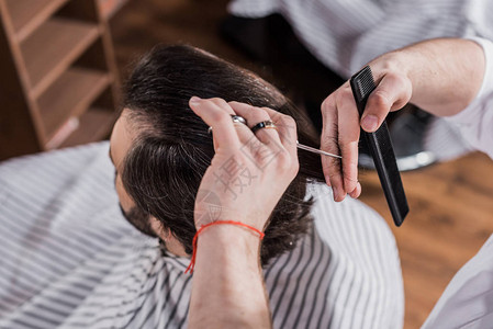 理发师用剪刀客户头发的高角度视图图片