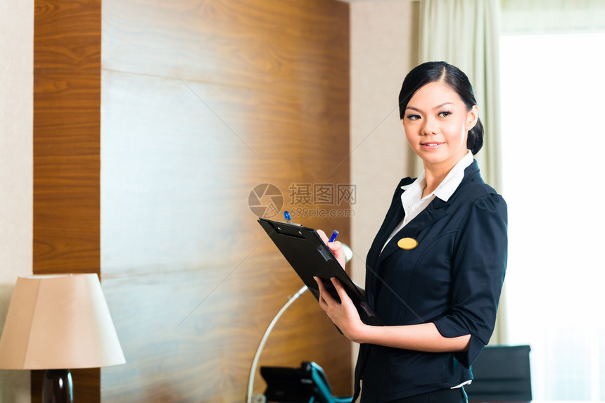 亚洲华人管家经理或助理控制或检查酒店的房间或西装图片