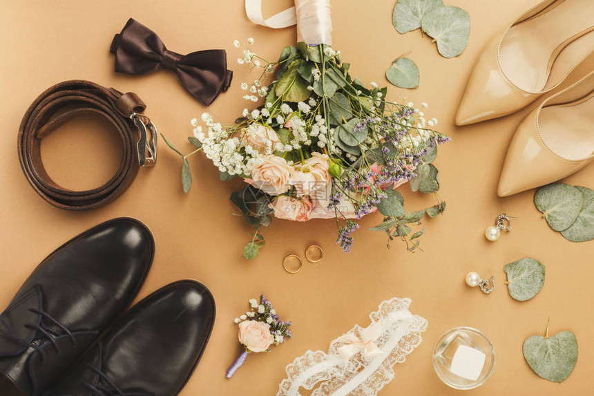 新娘和新郎鞋花卉胸花束金戒指的顶部视图婚礼概念的准图片