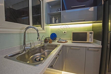 豪华公寓内带有金属水槽和水龙头的厨房室内图片